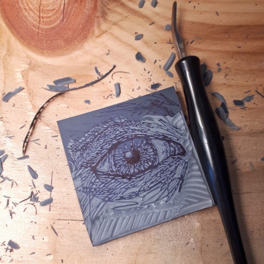 lino plate being carved with sketch of an eye
